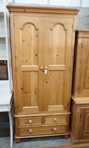 A modern narrow pine wardrobe, the base fitted with three drawers, width 92cm, depth 59cm, height 204cm